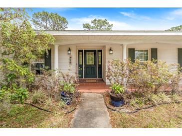 Inviting front entrance with black door, decorative plants, and a brick-paved walkway at 28 W Highbanks Rd, Debary, FL 32713
