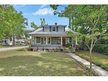 Charming two-story home with a metal roof, inviting front porch, and well-manicured lawn at 427 E Church St, Deland, FL 32724