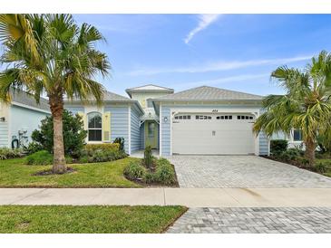 Charming single-Gathering home with a two-car garage, palm trees, and well-maintained landscaping at 464 Tropics Ave, Daytona Beach, FL 32124