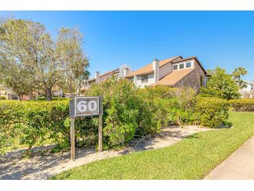 Inviting condo exterior with lush landscaping and a clear building number sign at 60 N Halifax Dr # 1050, Ormond Beach, FL 32176