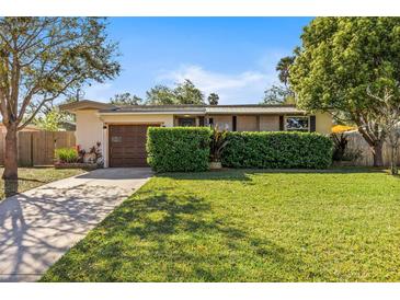 Charming single-story home with a well-manicured lawn, mature trees, and a private driveway at 617 S Flamingo Dr, Holly Hill, FL 32117