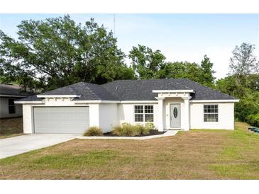 Charming single-story home with a well-maintained lawn, gray door and two-car garage at 815 Charles Ave, Orange City, FL 32763