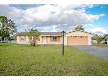 Charming single-story home featuring a well-manicured lawn, attached two-car garage, and inviting curb appeal at 902 Cloverleaf Blvd, Deltona, FL 32725