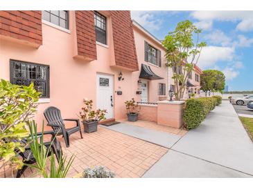 Charming townhome with peach exterior, red roof, and well-maintained landscaping at 108 Mitchell Pl # 108, Daytona Beach, FL 32118