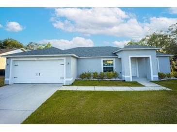 Charming one-story home with a well-maintained lawn, an attached garage, and a welcoming entrance at 1162 Prescott Blvd, Deltona, FL 32738