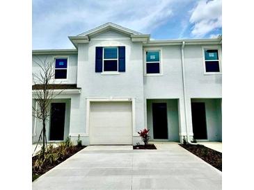 Modern townhome features a one-car garage and minimalist landscaping in the front yard at 131 Reena Dr, Daytona Beach, FL 32117