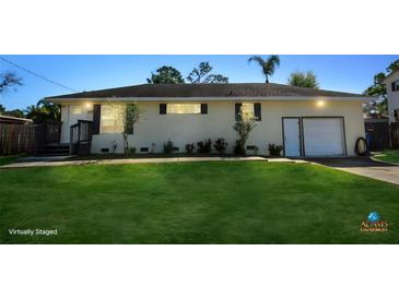 Charming single-story home with a well-manicured front lawn and an attached two-car garage at 1551 7Th Ave, Deland, FL 32724