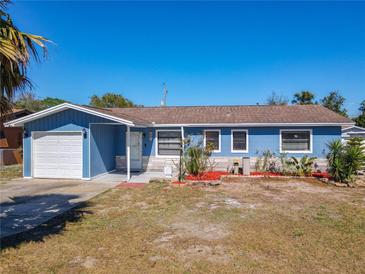 Charming blue single-story home with a well-manicured lawn and attached garage, perfect for comfortable living at 1767 Valencia Ave, Ormond Beach, FL 32174