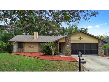 Charming one-story home with a well-maintained front yard, mature trees, and a brick and siding facade at 1880 N Merrick Dr, Deltona, FL 32738