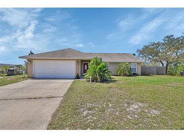 Inviting single-story home with a well-maintained lawn and a two-car garage at 1963 Stacey Cir, Deltona, FL 32738