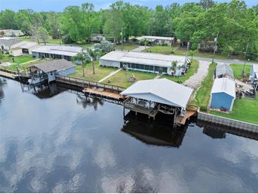Waterfront home featuring a private boat dock, canal access, and lush landscaping for serene waterfront living at 24919 Drive No 1, Astor, FL 32102