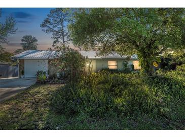 Charming home with mature trees and lush landscaping creating a serene and inviting entrance at 3228 Unity Tree Dr, Edgewater, FL 32141