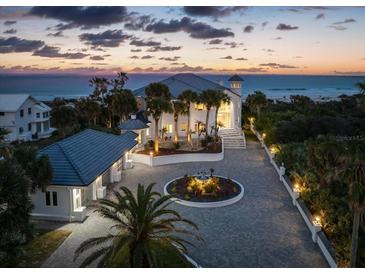 Stunning oceanfront home featuring a circular driveway, meticulous landscaping, and beautiful sunset views at 4911 S Atlantic Ave, Ponce Inlet, FL 32127