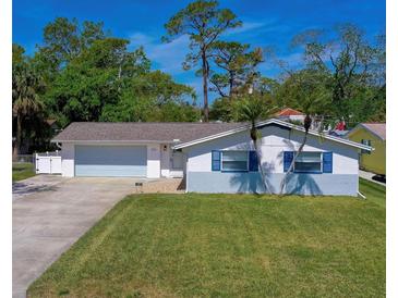 Charming single-story home with blue shutters and a well-manicured lawn, complemented by mature trees at 538 Gertrude Ln, South Daytona, FL 32119
