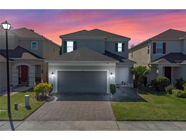 Charming two-story home with brick driveway, manicured lawn, and attached two-car garage at 544 Red Rose Ln, Sanford, FL 32771