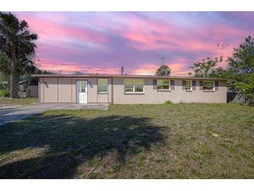 Charming single-story home featuring a well-manicured lawn and a serene, colorful sky at 852 Derbyshire Rd, Daytona Beach, FL 32117