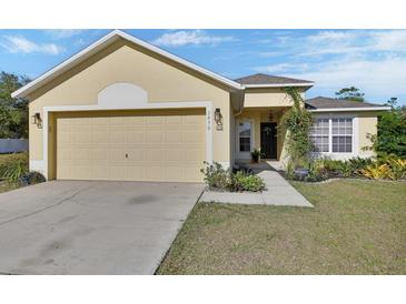 Charming single-story home with a two-car garage and inviting front garden landscaping at 3430 Arabesque Dr, Deland, FL 32724