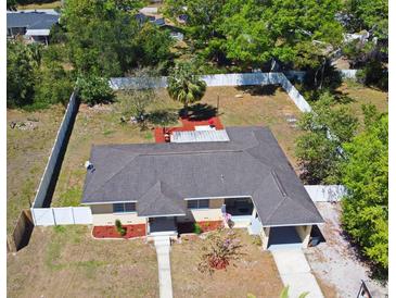 Aerial view of a quaint home featuring a fenced yard and mature trees providing ample shade, perfect for outdoor living at 10 Lilac Dr, Debary, FL 32713