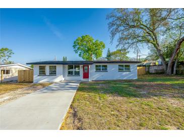 Charming single-story home featuring a freshly painted exterior, a bright red door, and a well-maintained front yard at 1304 Genmar St, Daytona Beach, FL 32117