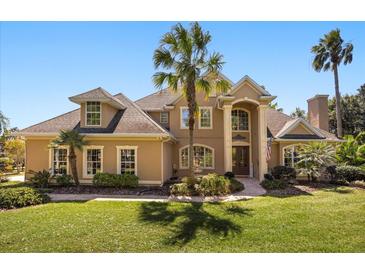 Stunning two-story home featuring mature landscaping, a manicured lawn, and classic architectural details at 1450 Shady Meadow Ln, Deland, FL 32724