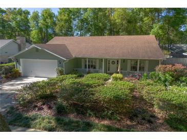 Charming single Gathering home with a well-manicured lawn, lush shrubbery, and an attached two-car garage at 1628 Bent Oaks Blvd, Deland, FL 32724