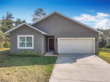 Charming single-story home featuring a two-car garage, neutral stucco siding and manicured landscaping at 1820 18Th St, Orange City, FL 32763