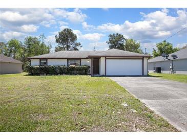 Charming single-story home with a well-manicured lawn and attached two-car garage at 2017 Monterey Dr, Deltona, FL 32738