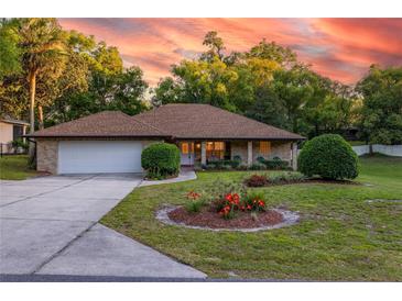 Charming brick home featuring a landscaped front yard, a driveway, and a two-car garage at 232 Westchester Dr, Deland, FL 32724