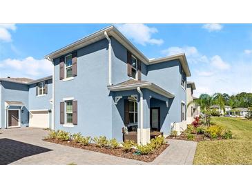 Beautiful exterior of a two-story home with a blue facade, brown shutters, and professionally landscaped yard at 3075 Meleto Blvd, New Smyrna Beach, FL 32168