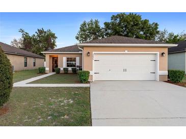 Charming home with a well-manicured lawn and a two-car garage at 3825 Arborvitae Way, Deland, FL 32724
