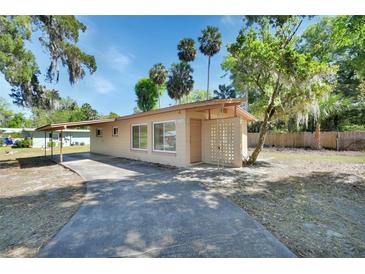 Charming single-story home featuring a mature landscaped yard, covered carport, and inviting front entrance at 530 Taylor Dr, Orange City, FL 32763