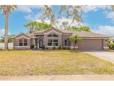 Charming single Gathering home featuring a 2-car garage, mature landscaping, and inviting curb appeal at 69 Grey Dapple Way, Ormond Beach, FL 32174