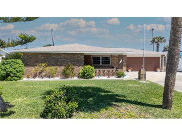 Charming brick home featuring a manicured front lawn and beautifully landscaped garden beds with white rock at 7 Kathy Dr, Ormond Beach, FL 32176
