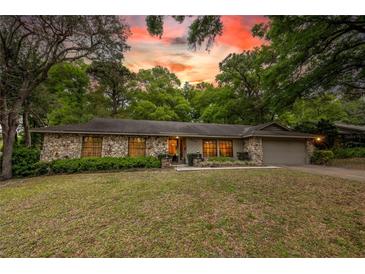 Charming single-story home with stone facade and mature landscaping, complete with attached garage at 929 Torchwood Dr, Deland, FL 32724