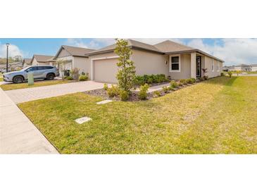 Charming single-story home with a well-manicured lawn, landscaped garden, and a brick-paved driveway at 207 Pitching Wedge Dr, Daytona Beach, FL 32124