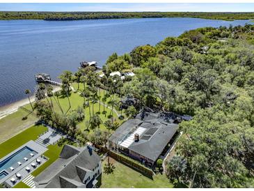Stunning aerial view of a waterfront property featuring a luxurious pool and a private dock on the tranquil river at 2149 Hontoon Rd, Deland, FL 32720