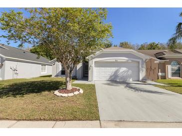 Charming single-story home featuring a well-manicured lawn and a two-car garage at 2274 Stonehedge Loop, Kissimmee, FL 34743