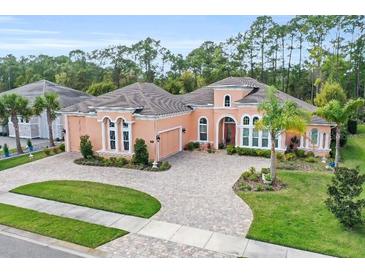 Stunning single-story home featuring a manicured front lawn, circular driveway and elegant arched windows at 2454 Hyatt Creek Ln, Port Orange, FL 32128