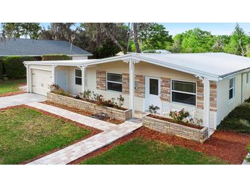 Charming single-story home with stone accents, brick walkway and manicured front garden at 3005 Garden Rd, Eustis, FL 32726