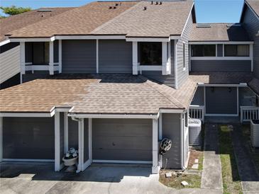 Exterior view of townhome featuring gray siding, attached garage, and well-maintained landscaping at 509 Lake Bridge Dr, Ormond Beach, FL 32174