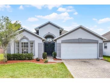 Charming single-story home with a well-manicured lawn, beautiful landscaping, and a two-car garage at 13944 Huntwick Dr, Orlando, FL 32837