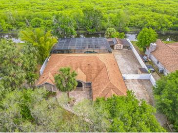 Stunning aerial view of a single-Gathering home with a screened pool, lush landscaping, and beautiful waterfront views at 1578 Stone Trl, Deltona, FL 32725