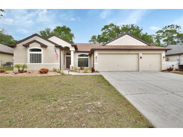 Charming single-story home featuring a three-car garage and well-maintained front yard with fresh landscaping at 1933 Oak Estates Dr, Orange City, FL 32763