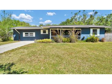 Charming single-story home with blue siding, white trim, and a cozy covered front porch at 1941 Jungle Rd, New Smyrna Beach, FL 32168