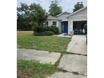 Charming home with a well-maintained lawn and a blue front door at 209 Meghan Cir, Deland, FL 32724