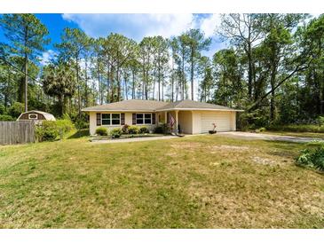 Charming single story home with a manicured lawn, mature landscaping and a two car garage in a wooded setting at 2309 6Th Ave, Deland, FL 32724