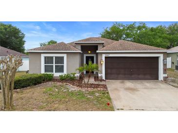 Charming single-story home featuring a well-maintained lawn and an attached two-car garage, with small palms enhancing curb appeal at 3267 Wild Pepper Ct, Deltona, FL 32725