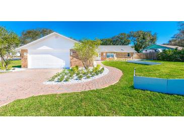Charming brick home featuring a two-car garage and a meticulously maintained front yard with beautiful landscaping at 4745 Dixie Dr, Ponce Inlet, FL 32127