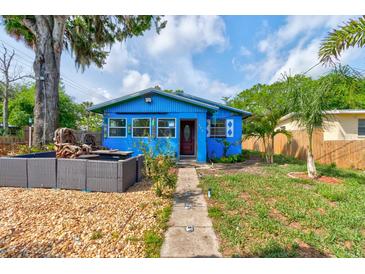 Charming blue single-story home with a well-manicured front yard, walkway, and patio area at 600 Holmes Ave, Daytona Beach, FL 32114