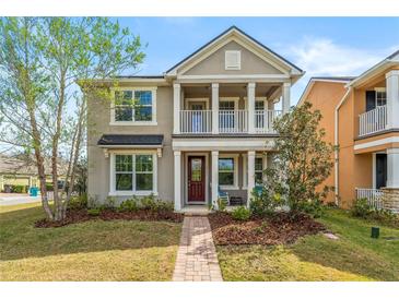 Charming two-story home with a quaint front porch and a beautifully landscaped yard at 8561 Randal Park Blvd, Orlando, FL 32832